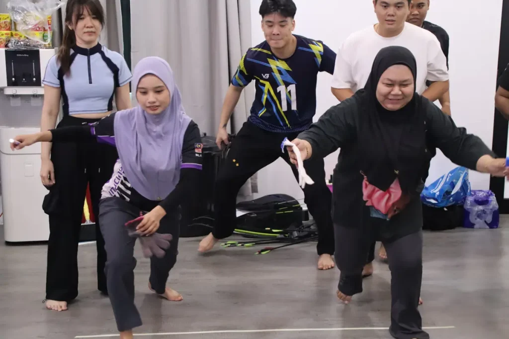 Peserta Kim Kok Enterprise menyertai cabaran berkumpulan dalam program team building di Melaka