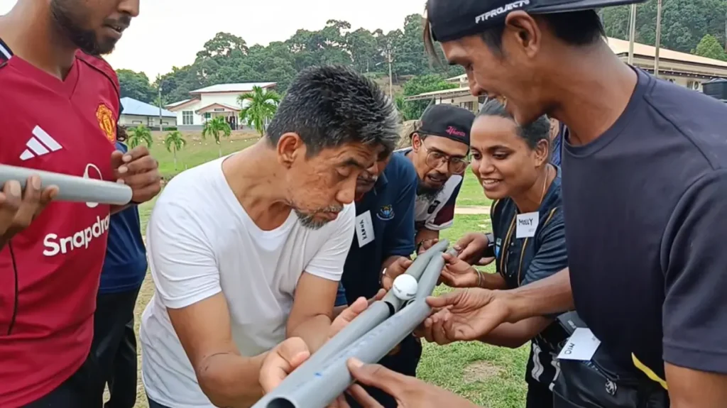 Peserta SUK Pulau Pinang bekerjasama dalam aktiviti Move On semasa program team building